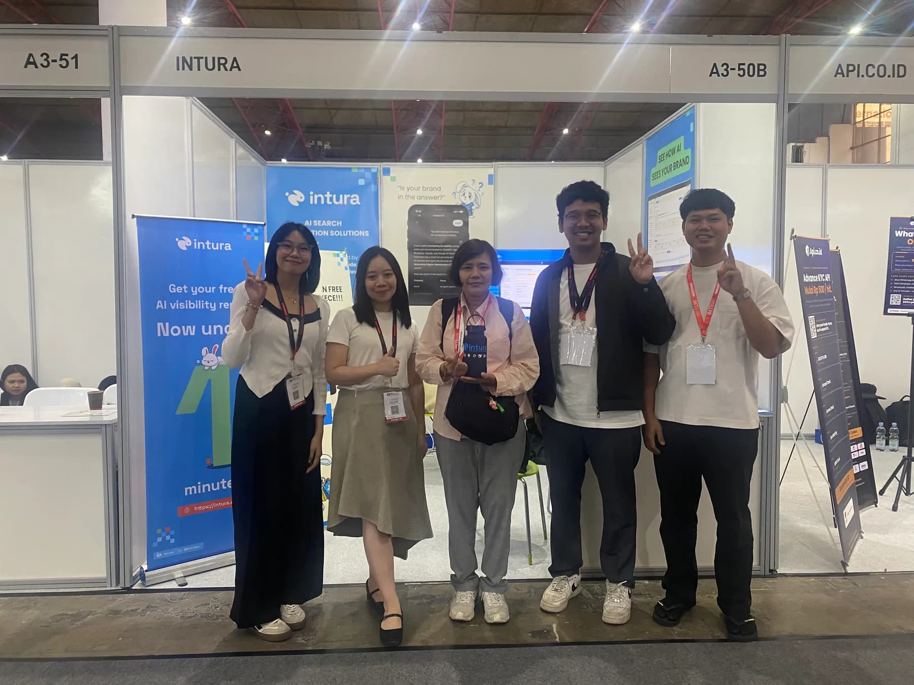 The Intura stand A3-50B at INTI 2026, JIExpo Jakarta, with roll-up banners offering a free AI visibility report and the neighbouring stands A3-51 and API.CO.ID either side